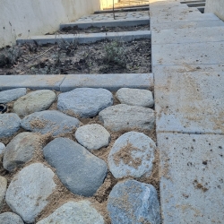 Belægning med store sten langs en havegang i Hjørring, der tilfører haven et rustikt og naturligt udseende.