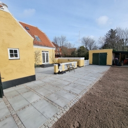 Nybelagt terrasse ved indgangen til en bolig i Aalborg. Fliserne skaber en stilfuld og holdbar belægning for udendørsarealet.
