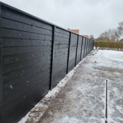 Nærbillede af et sort hegn i Aalborg med et moderne, minimalistisk design. Hegnet står langs en havegang og tilfører et stilfuldt element til udendørsområdet.